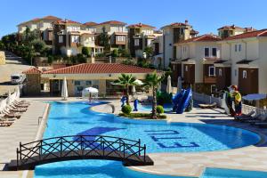 a view of a pool with a bridge and buildings at Ottoman Village in Alanya