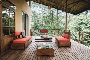 Huasquila Amazon Lodge في Cotundo: شاشة في الشرفة مع كرسيين وطاولة