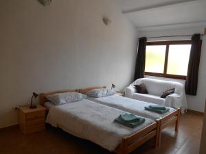 een slaapkamer met een bed, een stoel en een raam bij MIADEA in Rovinjsko Selo