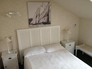 um quarto com uma grande cama branca com duas mesas de cabeceira em Villa Saint Hubert em Nice