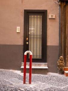 a red pole in front of a building with a door at B&B Cosmoneapolitan in Naples