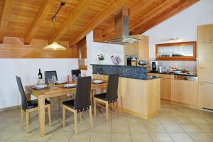 a kitchen with a wooden table with chairs and a counter at Chalet Z`Wichjehüs in Zermatt