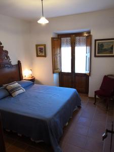 Schlafzimmer mit einem Bett mit blauer Decke in der Unterkunft Cal Nicet in Perafita