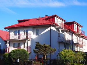 a white building with a red roof at Pensjonat Anker pokoje in Ustronie Morskie