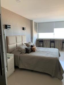 1 dormitorio con 1 cama grande y ventana grande en Studio Atlântica II en Río de Janeiro