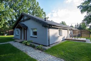 una piccola casa bianca con un patio in un cortile di Apartamenty Podwarszawskie a Stara Wieś