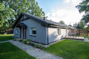 a small white house with a patio in a yard at Apartamenty Podwarszawskie in Stara Wieś