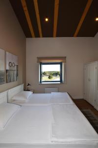 two white beds in a room with a window at Bed&Breakfast Monte Rosso in Poreč