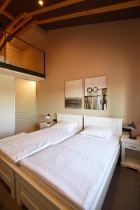 een slaapkamer met een groot wit bed met 2 foto's aan de muur bij Bed&Breakfast Monte Rosso in Poreč