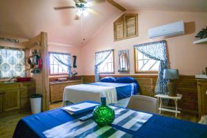 a bedroom with two beds and a table with a vase on it at Blue Island Divers Casita Azul in Sandy Bay