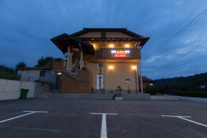 a gas station with a lit up sign in a parking lot at Apartments Bašić in Visoko
