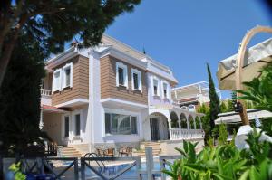 a large house with a porch and chairs in front of it at Ottoman Village in Alanya