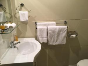 ein Badezimmer mit einem weißen Waschbecken und Handtüchern in der Unterkunft Balranald Club Motel in Balranald + 17 Fotos