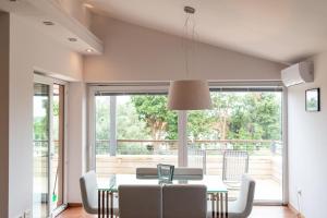 une salle à manger avec une table et des chaises et une grande fenêtre dans l'établissement House Mia, à Ližnjan