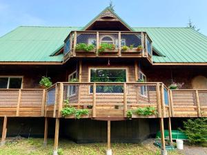 a house with a deck with potted plants on it at Sourdough Sunrise B&B in Seward