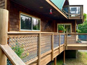een houten veranda van een huis met een terras bij Sourdough Sunrise B&B in Seward