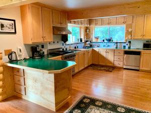 a kitchen with wooden cabinets and a green counter top at Sourdough Sunrise B&B in Seward