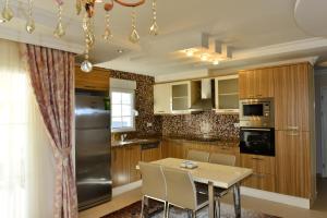 a kitchen with wooden cabinets and a table with chairs at Ottoman Village in Alanya