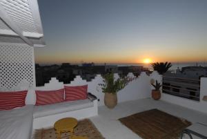 a balcony with a couch and a view of the city at Darmimouna in Asilah