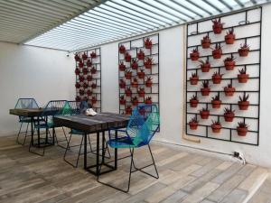 a room with tables and chairs and a wall with potted plants at Moloch Hostel & Suites in Cancún