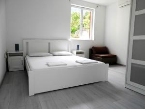 Un dormitorio blanco con una cama blanca y una ventana en Hrstich Apartments, en Drasnice