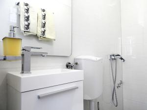 Baño blanco con lavabo y aseo en Hrstich Apartments, en Drasnice