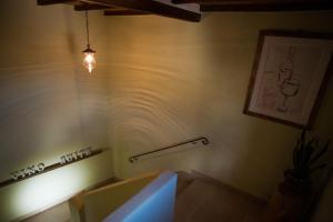 a room with a staircase with a light on the wall at VINO SUITE in San Quirico dʼOrcia