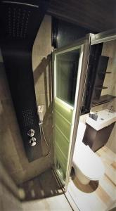 a bathroom with a toilet and a glass shower at Perneia Rooms in Askas