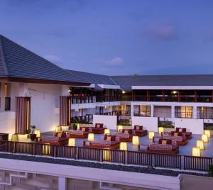 an exterior view of a hotel with chairs and tables at The Bandha Hotel & Suites in Legian