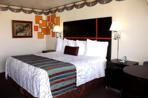 a hotel room with a large bed with white sheets at Chaparral Motor Inn in Burlington