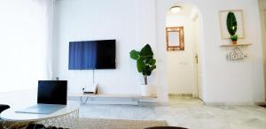 Телевизор и/или развлекательный центр в ROQUETAS BEACH HOUSE Apartamento fresco con Piscina