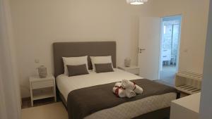 a bedroom with a bed with two teddy bears on it at Casinha D'Avó in Nazaré