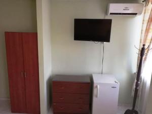 una camera con TV a parete e frigorifero di Hotel Marli Plaza a Mocoa