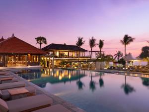 una piscina resort con sillas y un edificio en Bali Niksoma Boutique Beach Resort en Legian