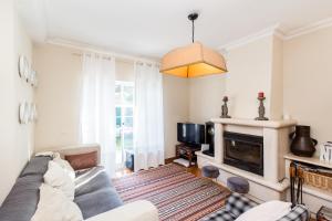 a living room with a couch and a fireplace at Magnólia Beach House - Cascais in Cascais