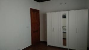 1 dormitorio con paredes blancas, armario y puerta en Casa Los Almendros Jacuzzi Garden, en Puntagorda
