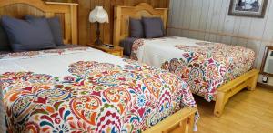 a bedroom with two beds with colorful blankets at Marshall's Creek Rest Motel in Gatlinburg