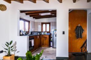 cocina con paredes blancas y armarios de madera en Nibiru Hostel en Villa de Leyva