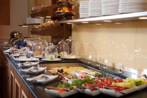 a buffet line with plates of food in a restaurant at Hotel Kaiserhof Wien in Vienna