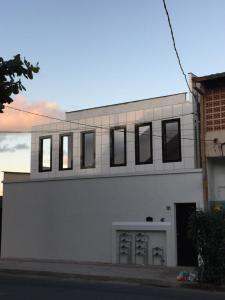 a white building with windows on the side of it at Apto Floramar in Belo Horizonte