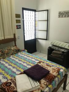 a bedroom with a bed with a quilt on it at Apto Floramar in Belo Horizonte