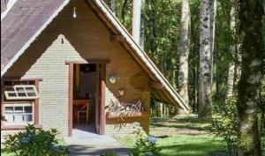 a small brick house in the middle of a forest at Pousada ao nascer do sol in Gonçalves +8 photos