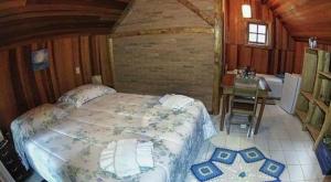 a bedroom with a bed and a sink and a desk at Pousada ao nascer do sol in Gonçalves