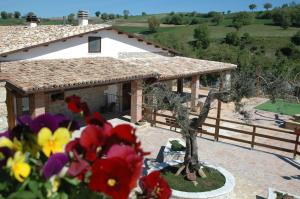 a house with a garden with flowers in front of it at Agriturismo Fontefredda in Tavenna