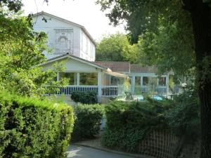 une maison blanche avec une cour entourée de buissons dans l'établissement Hotel & Restaurant Heliotel, à Montferrier-sur-Lez