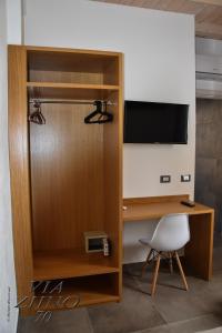 a room with a tv and a desk and a chair at Via Ziino 70 in Oliveri