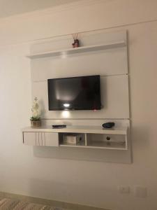 a flat screen tv on a white wall at Hotel Cavalinho Branco - Apartamento 516 in Águas de Lindóia
