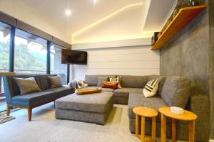 a living room with a couch and two chairs at Mowamba F2 in Thredbo