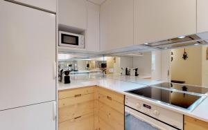 a large kitchen with white cabinets and a microwave at St. Moritzerhof 42 in St. Moritz