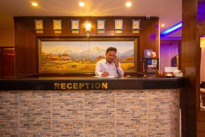 mężczyzna rozmawiający przez komórkę w barze w obiekcie Hotel Crystal Palace w mieście Pokhara